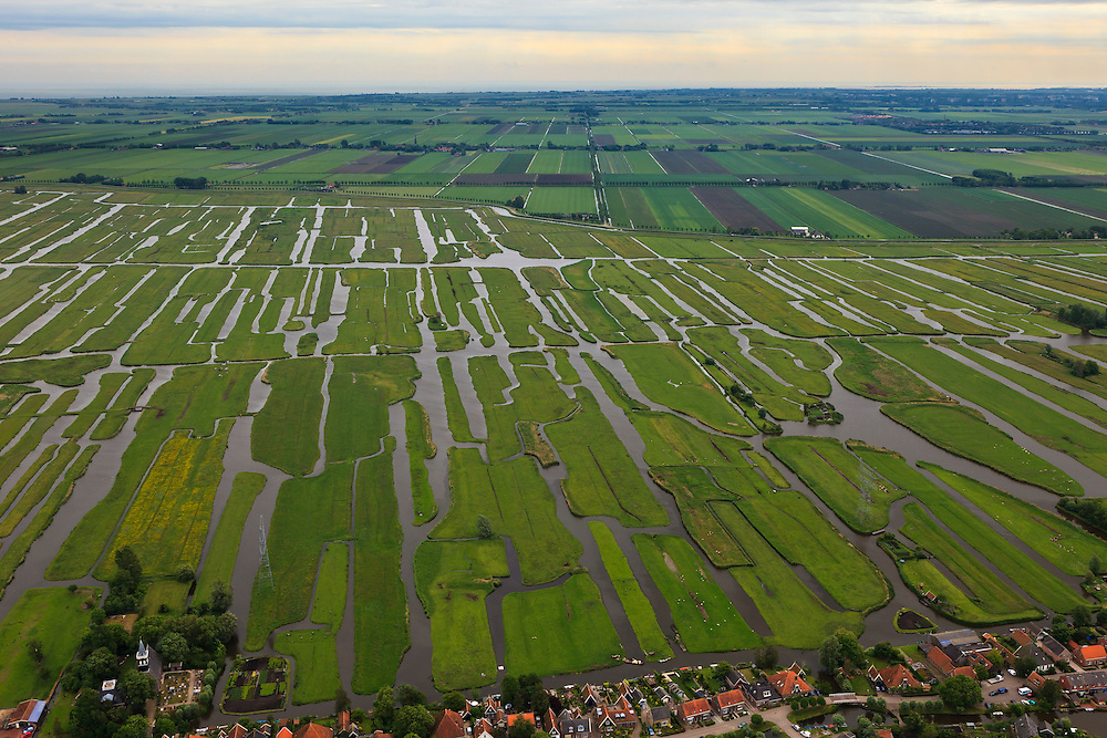 Nederland, Noord-Holland, Gemeente Schermer, 22-05-20011; Grootschermer en Eilandspolder, polder met laagveen, voormalig veeneiland tussen de toenmalige meren Schermer en Beemster. De polder Beemster, op het tweede plan, kent een strakke verkaveling (geometrische raster), dit in tegenstelling tot het grillige landschap van de Eilandspolder, wat ontstaan is door drainage en vervening (winnen van turf). IJsselmeer aan de horizon.
De Eilandspolder is in gebruik als weide- en hooiland en is beschermd natuurgebied voor water- en weidevogels. 
Irregular pattern of drainage ditches in typical Dutch peatland polder in the foreground. Contrasts with the geometrical well-ordered polder Beemster in the background which consists of reclaimed land.
luchtfoto (toeslag); aerial photo (additional fee required); .foto Siebe Swart / photo Siebe Swart